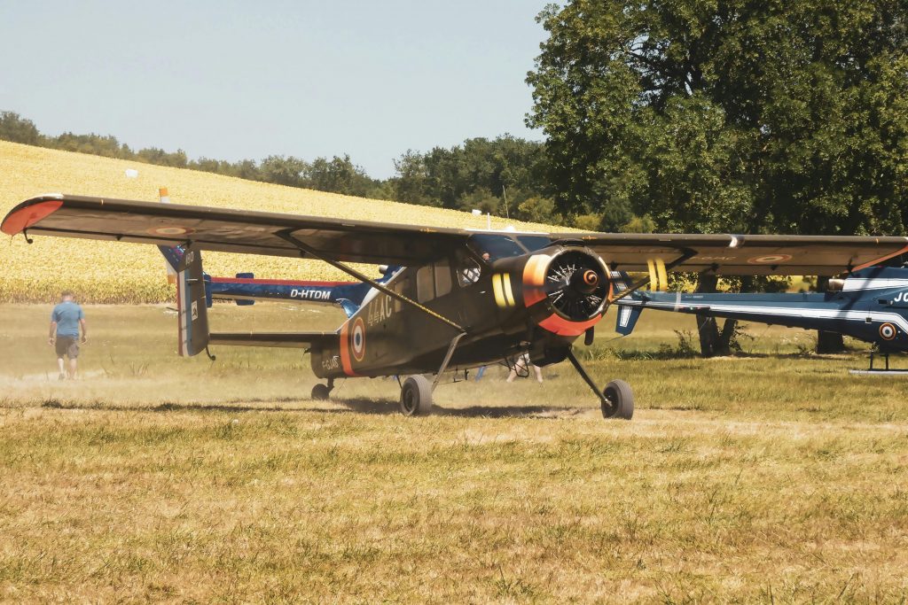 A vintage aircraft in Val des Vignes, France, parked on a grassy field, highlighting aviation history.